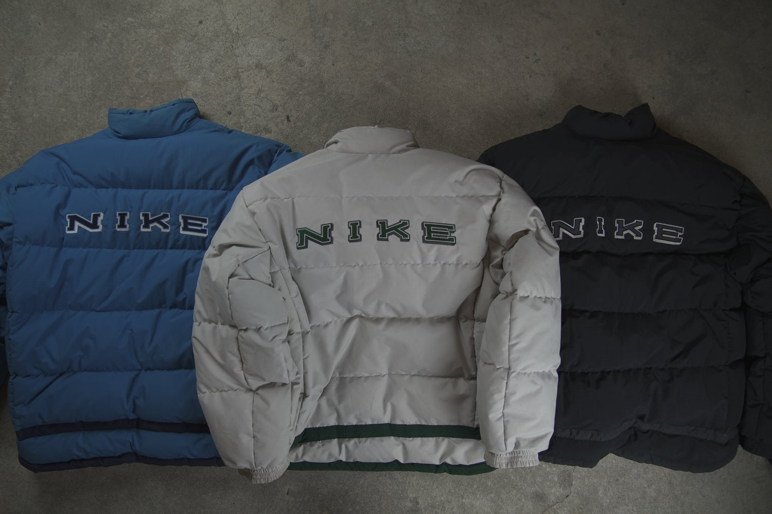 Three Nike Vintage Puffer Jackets in Blue, White and Black -embroidered spell out on the back -2000s edition